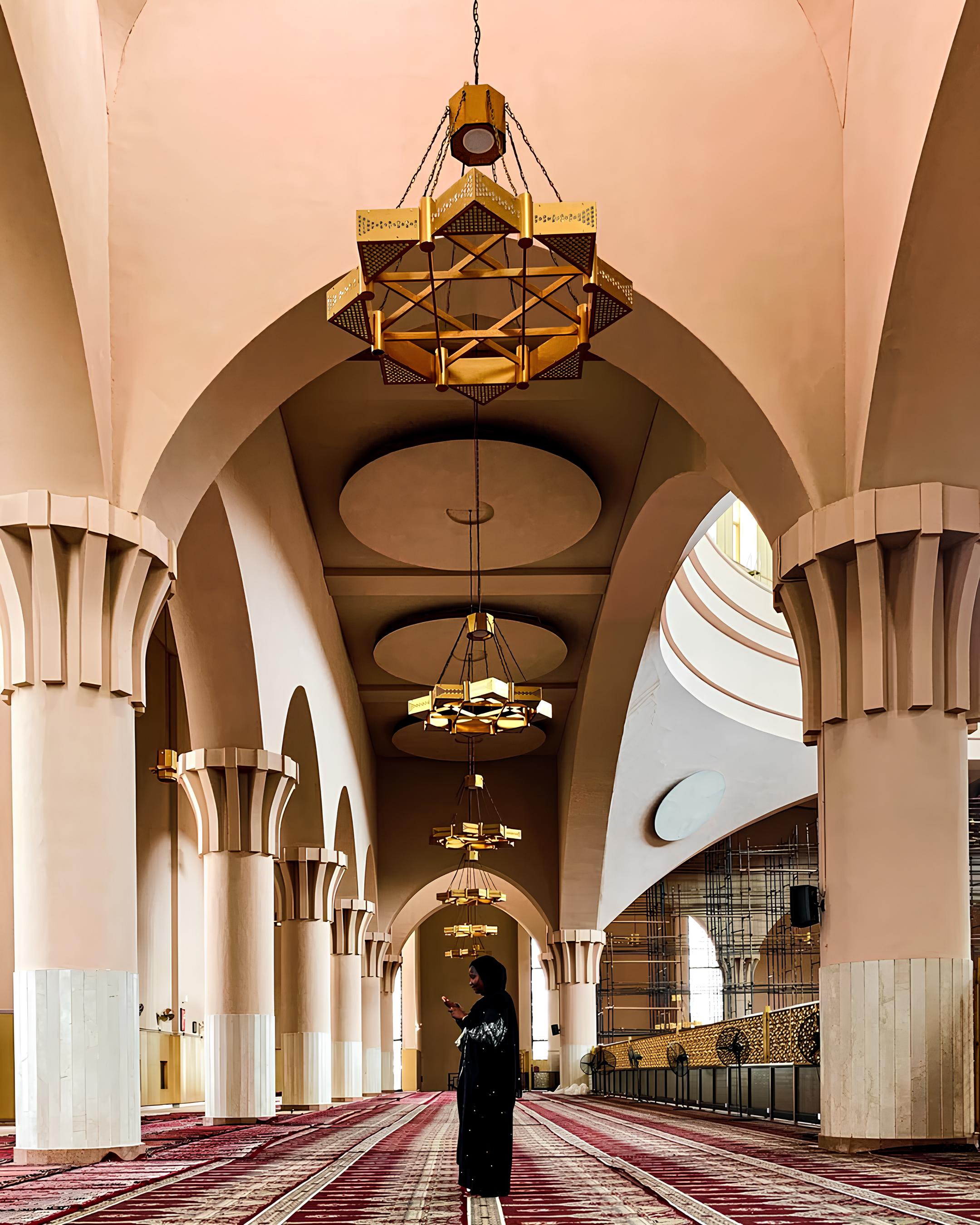 Iklima Babangida reviewing camera settings outdoors in magenta attire